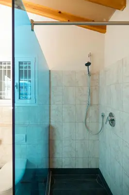 a shower with a glass door in a bathroom at Zoe's Place - 1 BD Loft Beachfront Apartment in Kissamos