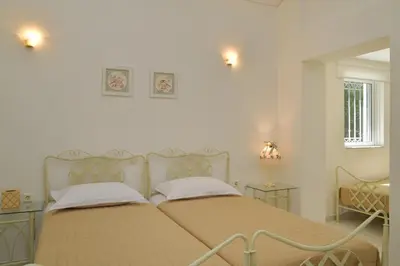 a bedroom with two beds and two tables at Villa Raks in Kántanos