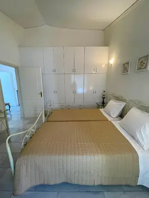 a bedroom with a large bed with white cabinets at Villa Raks in Kántanos