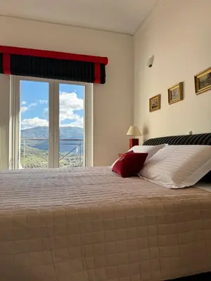 a bedroom with a large bed with a large window at Villa Raks in Kántanos