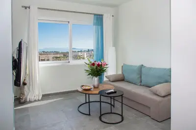a living room with a couch and a window at Kolymvari Hills in Chania Town