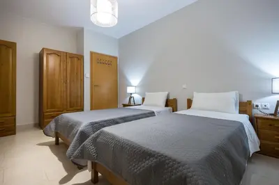 a bedroom with two beds and a cabinet at Zoe's Place - 2 BD Beachfront Apartment in Kissamos