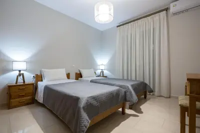 a bedroom with two beds and a window at Zoe's Place - 2 BD Beachfront Apartment in Kissamos