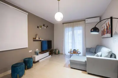 a living room with a couch and a tv at Zoe's Place - 2 BD Beachfront Apartment in Kissamos