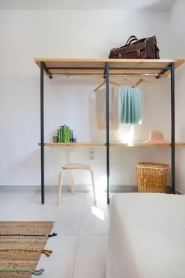 a room with a shelf and a table and a stool at Olive Apt - Akrotiri in Kounoupidhianá
