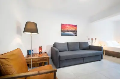 a living room with a couch and a bed at Olive Apt - Akrotiri in Kounoupidhianá