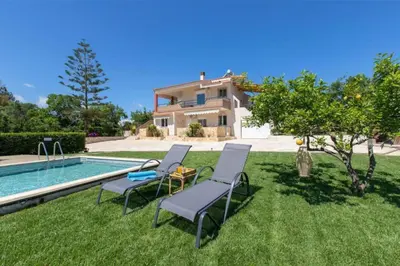 a yard with two chairs and a swimming pool at VILLA APELLA - PRIVATE HEATED POOL in Nohia