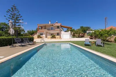 a villa with a swimming pool in front of a house at VILLA APELLA - PRIVATE HEATED POOL in Nohia