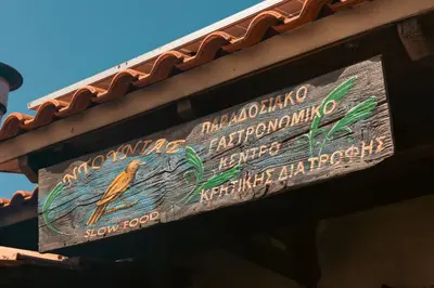 a sign on the side of a building with a bird on it at House Of Ntounias ΙΙ in Dhrakóna