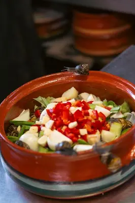 a bowl of food with vegetables in it on a plate at House Of Ntounias ΙΙ in Dhrakóna