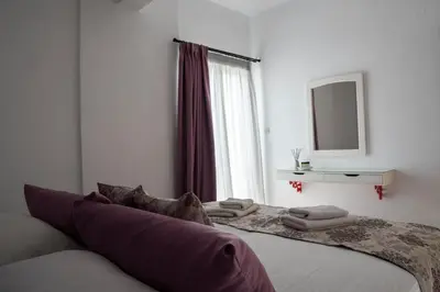 a bedroom with a bed with a mirror and a window at Michael Apartments 2 in Agia Marina Nea Kydonias