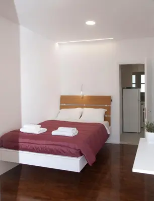 a bedroom with a large bed with a red blanket at Vabis Koum - Kapi in Chania Town