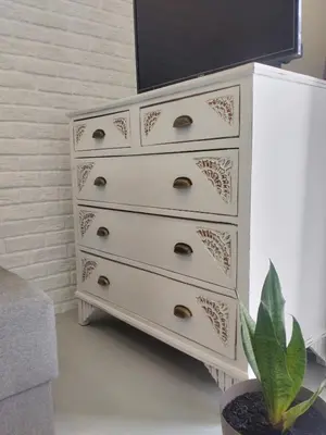 a white chest of draws with a potted plant at Vabis Koum - Kapi in Chania Town