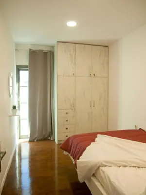 a bedroom with a bed and a closet and a window at Vabis Koum - Kapi in Chania Town
