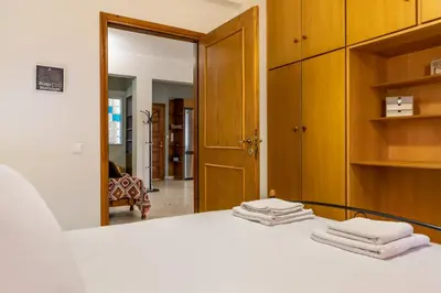 a bedroom with a white bed and a mirror at Big spacious apartment in the heart of the city! in Chania Town