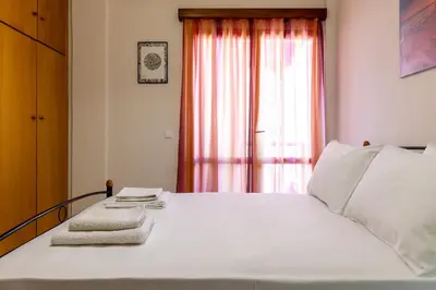 a bedroom with a white bed with a window at Big spacious apartment in the heart of the city! in Chania Town