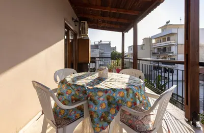a table on a balcony with a table and chairs at Big spacious apartment in the heart of the city! in Chania Town