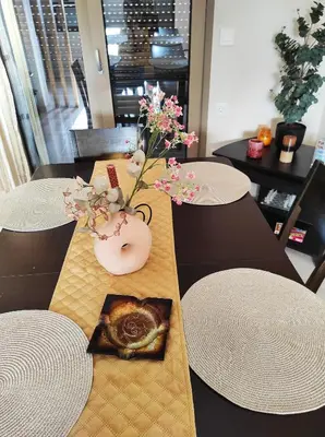a table with white tables and a vase with flowers on it at TziApartment in downtown Chania in Chania Town