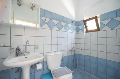 a blue and white bathroom with a toilet and a sink at MYLOS (6) in Chania Town