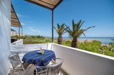 a table and chairs on a balcony with a view of the ocean at MYLOS (6) in Chania Town
