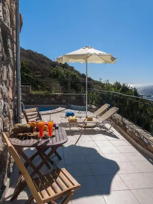 a patio with a table and chairs and an umbrella at Seaview villa Amphitriti with Private Pool, 20 min from Elafonissi beach in Chania Town