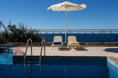 a swimming pool with two chairs and an umbrella at Seaview villa Amphitriti with Private Pool, 20 min from Elafonissi beach in Chania Town