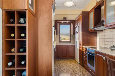 a kitchen with wooden cabinets and a window at Sunset Apartment in Platanias in Plataniás