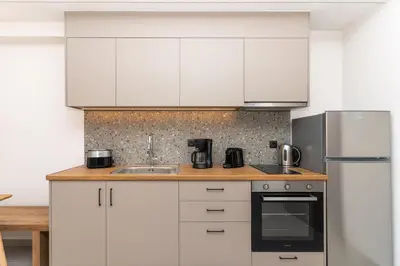 a kitchen with white cabinets and stainless steel appliances at Dreta Suites in Chania Town