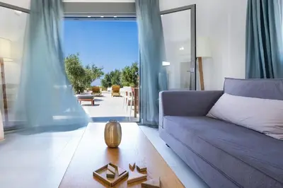 a living room with a purple couch and a large window at Olisea Villa, olive grove seaview villa in Kounoupidhianá