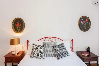 a bedroom with a white bed with pillows and two tables at House of joy close to Chania center in Chania Town