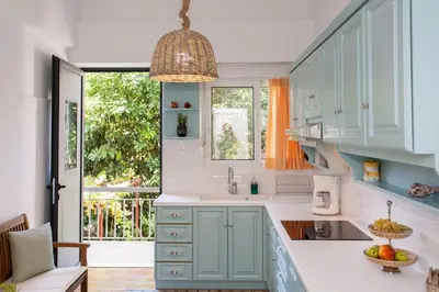 a kitchen with blue cabinets and a large window at House of joy close to Chania center in Chania Town