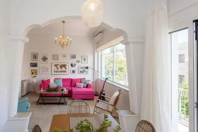 a living room with a pink couch and a table at House of joy close to Chania center in Chania Town