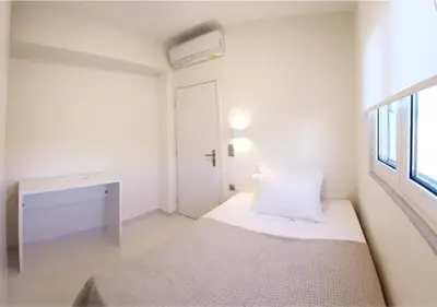 a white room with a bed and a window at White Dome Apartment I in Souda