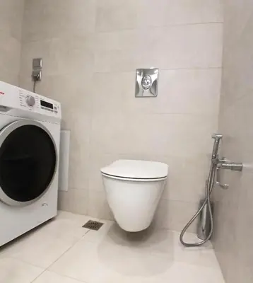 a bathroom with a toilet and a washing machine at White Dome Apartment I in Souda