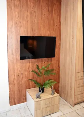 a living room with a tv on a wooden wall at Relaxed Dream home in Chania Town