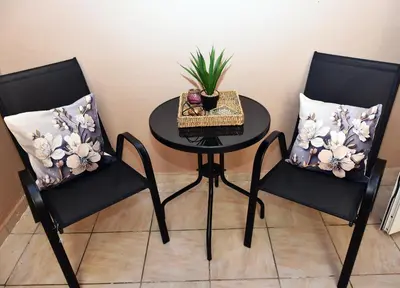 two black chairs with a table and a plant on it at Relaxed Dream home in Chania Town
