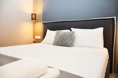 a bed with white sheets and pillows in a room at Relaxed Dream home in Chania Town