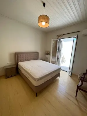 a bedroom with a bed and a large window at The Gem Of Talos Apartment in Stalos