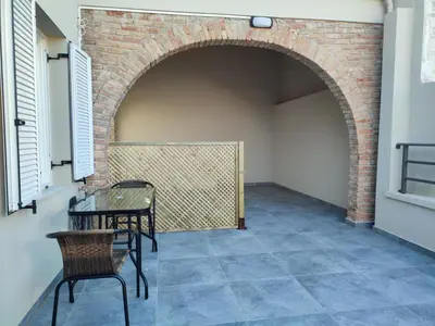 a patio with an archway and a table and chairs at The Gem Of Talos Apartment in Stalos