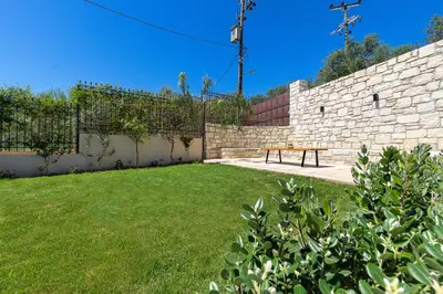 a picnic bench in a yard next to a brick wall at Villa Giannari in Stalos