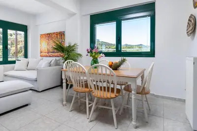 a living room with a table and chairs and a couch at Villa Giannari in Stalos