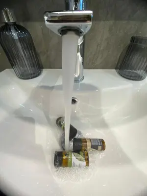 a bottle of wine is under the water in a sink at Rouan Studios in Souda