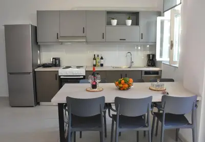 a kitchen with a table with chairs and a bowl of fruit on it at Para thin alós House in Chania Town