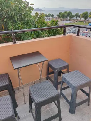 a table and four stools on a balcony at Para thin alós House in Chania Town