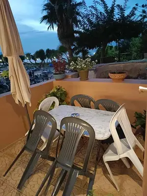 a table and chairs on a balcony with an umbrella at Para thin alós House in Chania Town