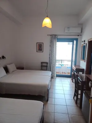 a hotel room with two beds and a balcony at Lissos Studios - Rooms in Palaiochóra