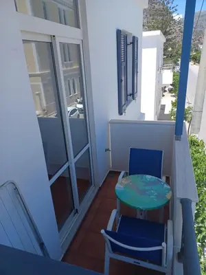 a balcony with two chairs and a table on it at Lissos Studios - Rooms in Palaiochóra