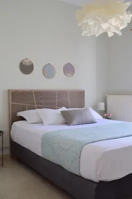 a bedroom with a large bed with white sheets at ELflat - chania city living in Chania Town