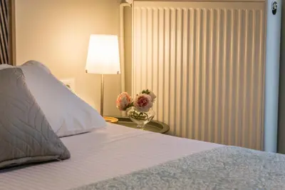 a bedroom with a bed and a table with a vase of flowers at ELflat - chania city living in Chania Town
