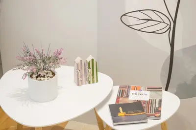 a white table with a plant and books on it at ELflat - chania city living in Chania Town